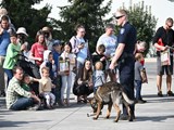 K9 Officer with his K9 giving a demonstration to a group of people.