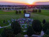 Aerial view of Settlers Park in the sunset with a crowd gathered for a movie night