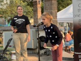A young child at a microphone on a stage